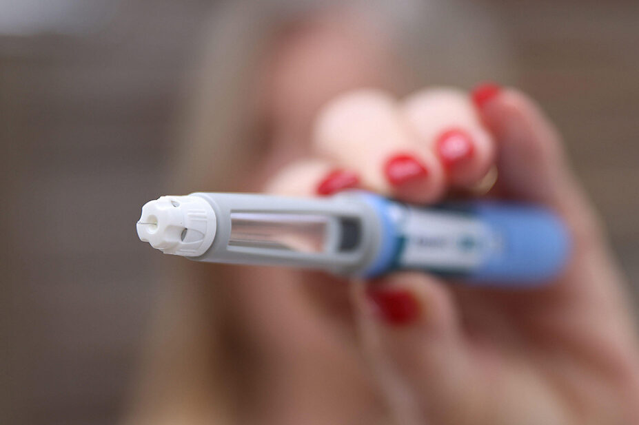 A woman holds an weight-loss injection pen