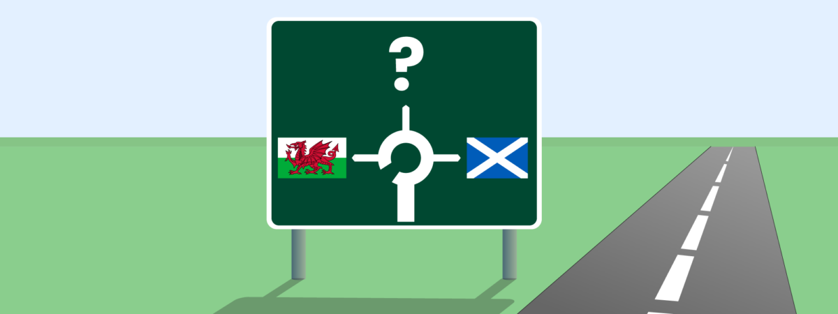 Motorway style sign with Welsh flag and Scottish flag showing destinations and a question mark to represent England. Road to the right