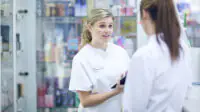 Two young pharmacists having conversation