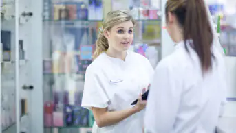 Two young pharmacists having conversation