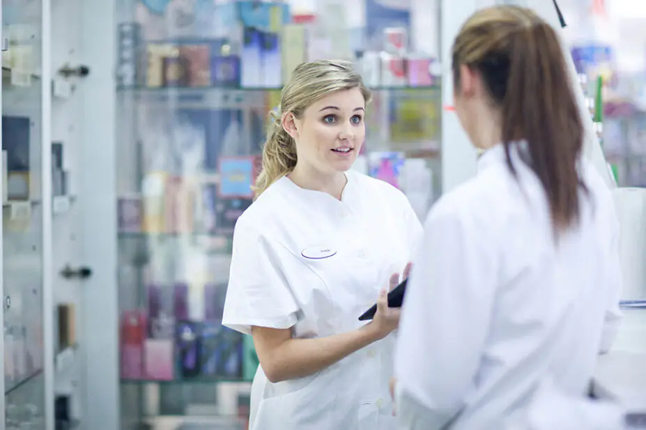 Two young pharmacists having conversation