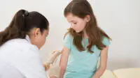 A child receives a vaccination from a healthcare professional