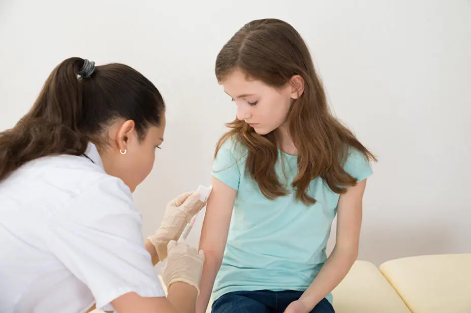 A child receives a vaccination from a healthcare professional