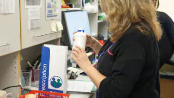A pharmacist fills a prescription for a patient