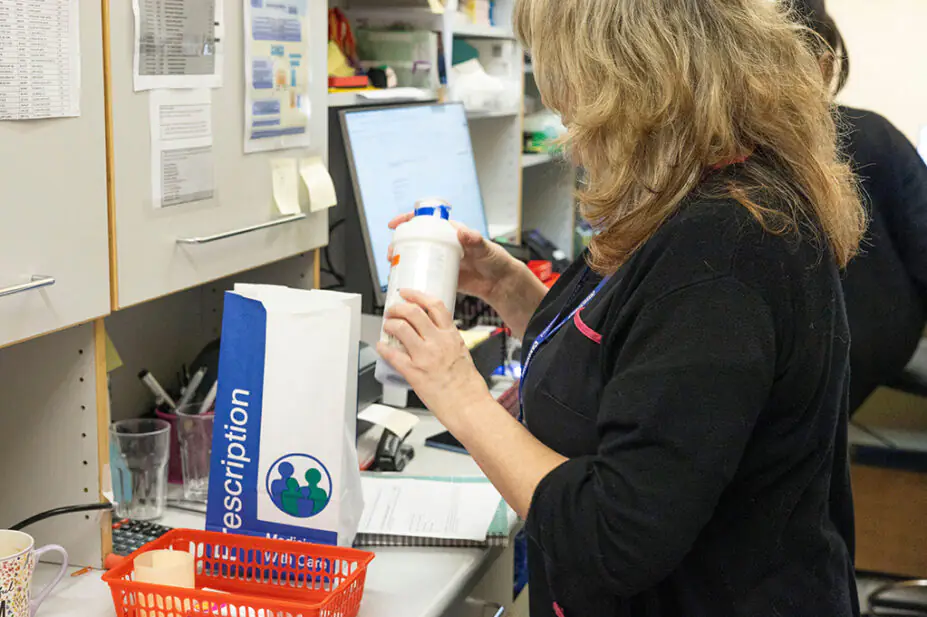 A pharmacist fills a prescription for a patient