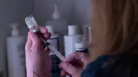 Healthcare professional preparing a syringe of medicine