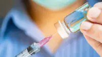 Physician holding a syringe in preparation to administer