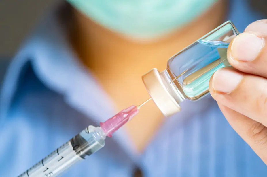 Physician holding a syringe in preparation to administer