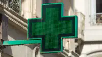 Close-up of pharmacy sign on the exterior of a building in London