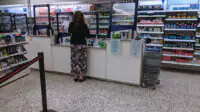 A woman at a pharmacy counter in UK pharmacy store
