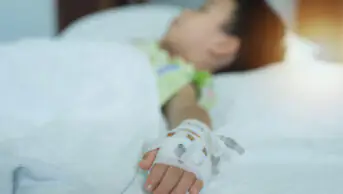 Young child with cannula in hospital bed