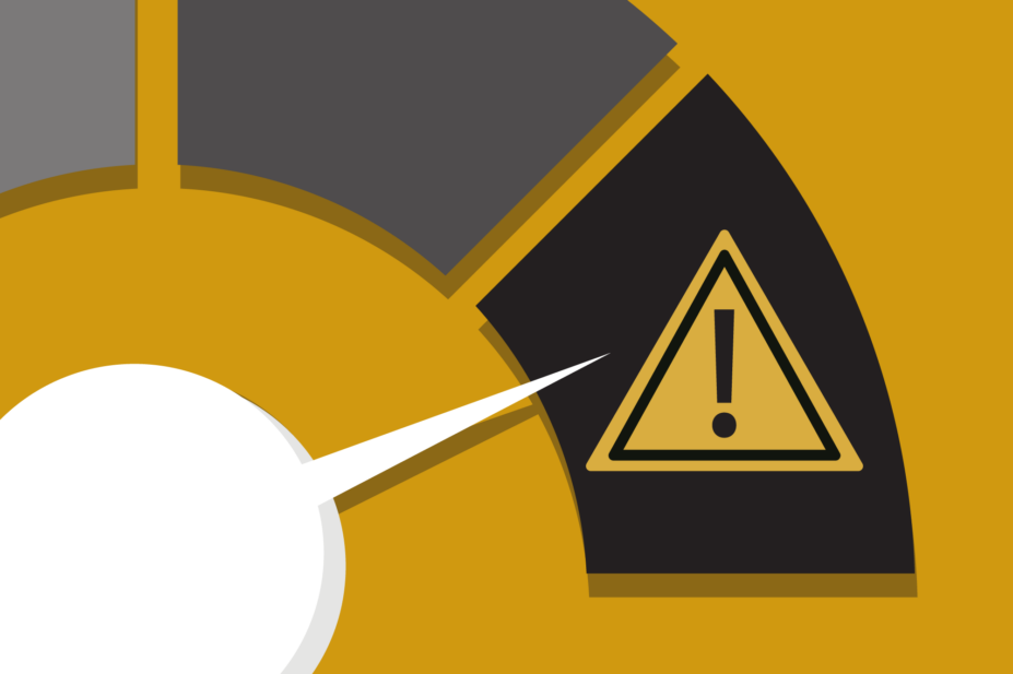Yellow background showing a white dial with increasingly dark sections. The dial is close to the highest setting showing a warning sign