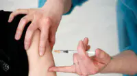 A healthcare professional gives a vaccination to a patient