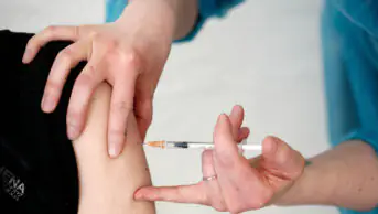 A healthcare professional gives a vaccination to a patient