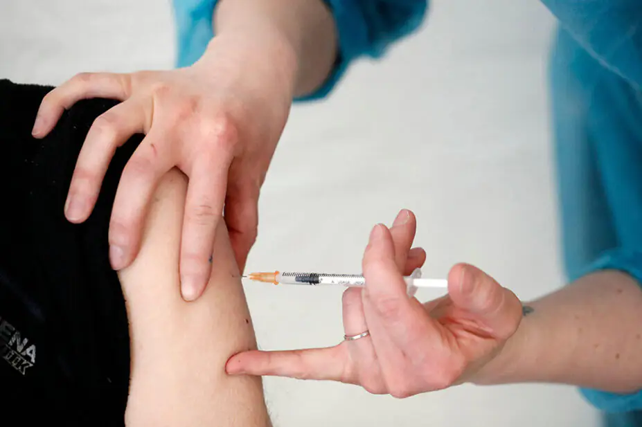 A healthcare professional gives a vaccination to a patient