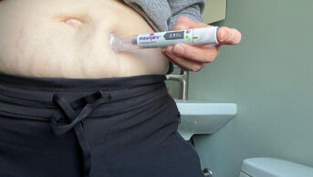A woman injects herself with a weight-loss pen