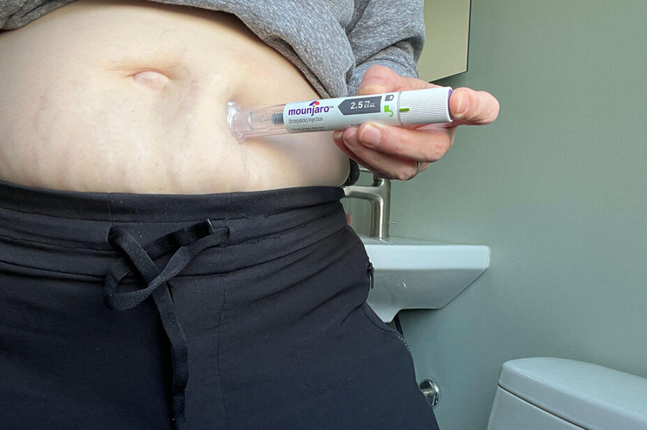 A woman injects herself with a weight-loss pen