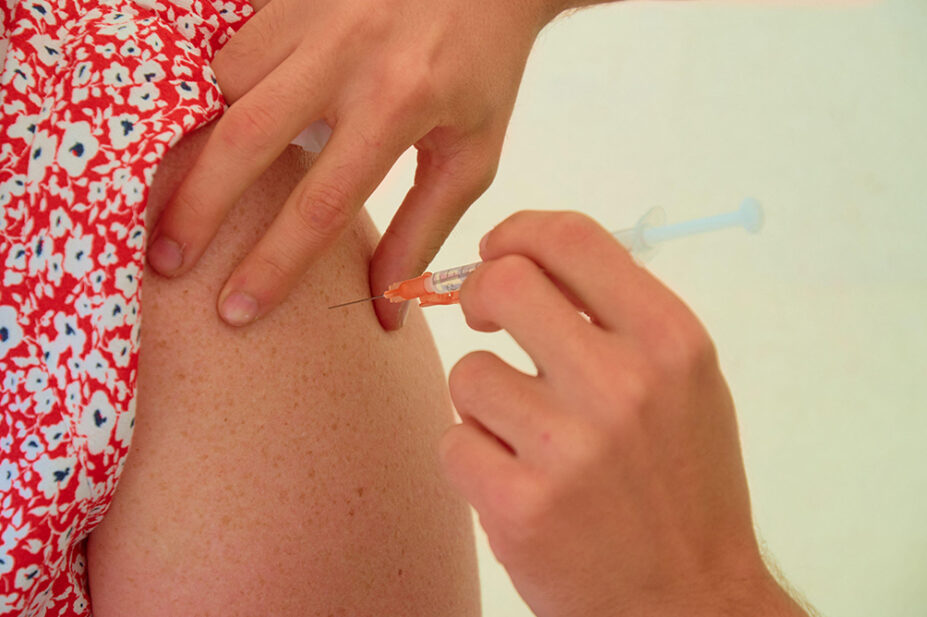 A woman receives a vaccination in her arm