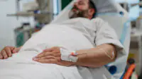 Middle aged man lying in hospital bed