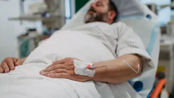Middle aged man lying in hospital bed