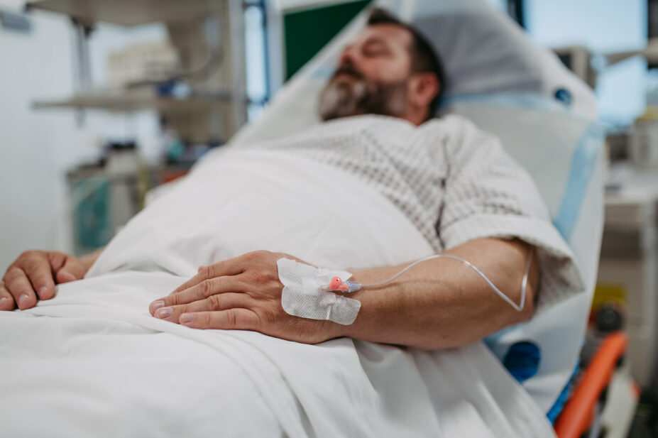 Middle aged man lying in hospital bed
