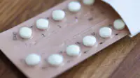 Women contraceptive hormonal birth control pill packet on a wooden desk