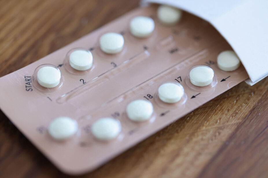 Women contraceptive hormonal birth control pill packet on a wooden desk