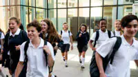 A group of teenagers in school uniform walking together