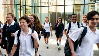 A group of teenagers in school uniform walking together