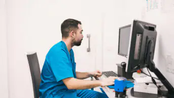 A healthcare professional checks patient records on a computer