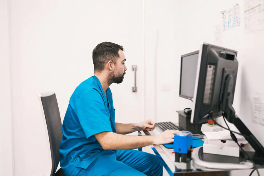 A healthcare professional checks patient records on a computer