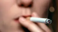 A woman smokes a cigarette