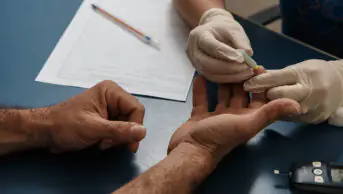 Physician taking blood sugar test