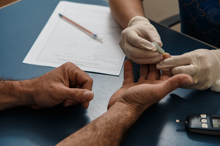 Physician taking blood sugar test