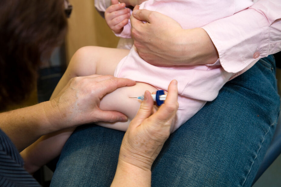 C2F74W MMR etc immunisation / inoculation / jab / from a syringe into a one year old / 12 13 twelve thirteen month baby's thigh / leg.