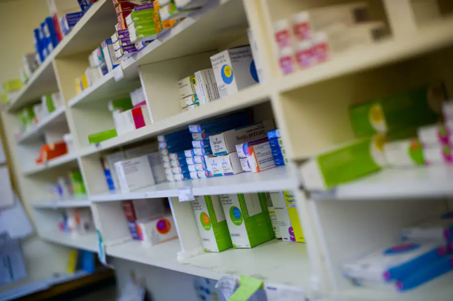 Dispensary chemist display shelves of drugs and packets