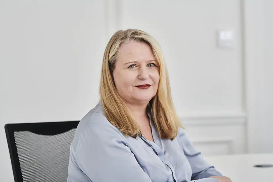 Janet Morrison sat at a desk wearing blue shirt