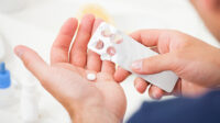 Man holding a blister pack of tablets