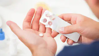Man holding a blister pack of tablets