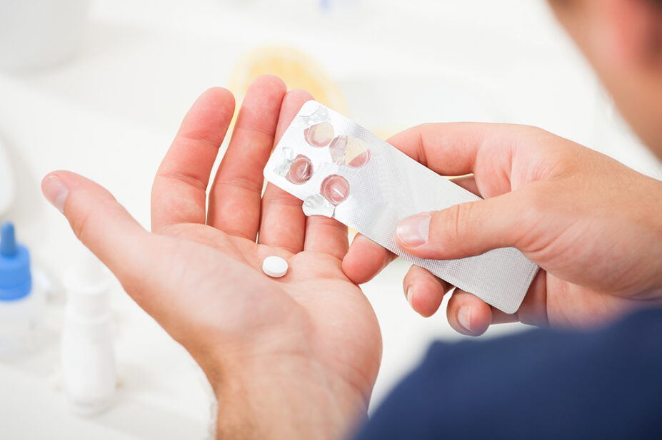 Man holding a blister pack of tablets