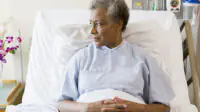Senior Woman Sitting In Hospital Bed