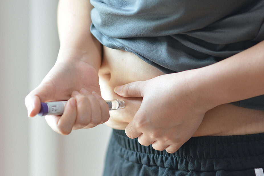 A person injects their abdomen with a weight-loss injection