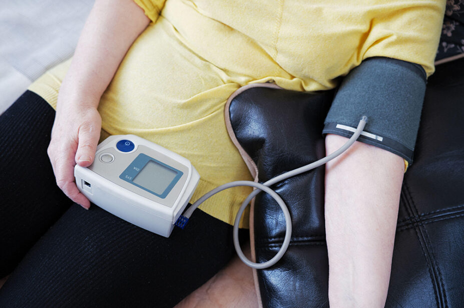 An older woman checks her blood pressure