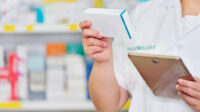 A community pharmacist checks medication with a tablet