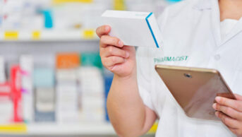 A community pharmacist checks medication with a tablet