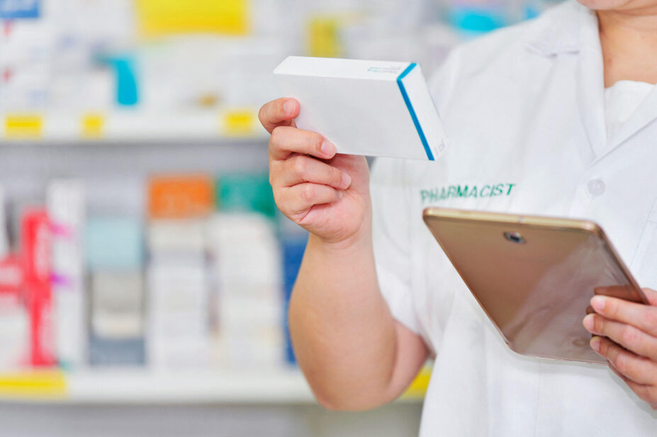 A community pharmacist checks medication with a tablet