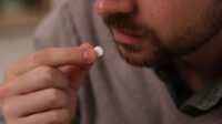 A man takes a white pill