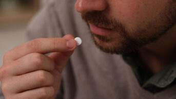 A man takes a white pill