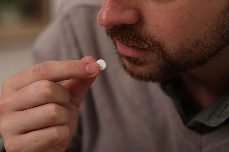 A man takes a white pill