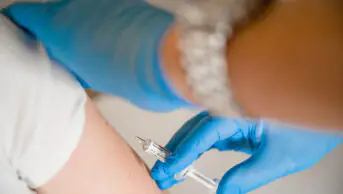 A patient receives a vaccination from a healthcare professional